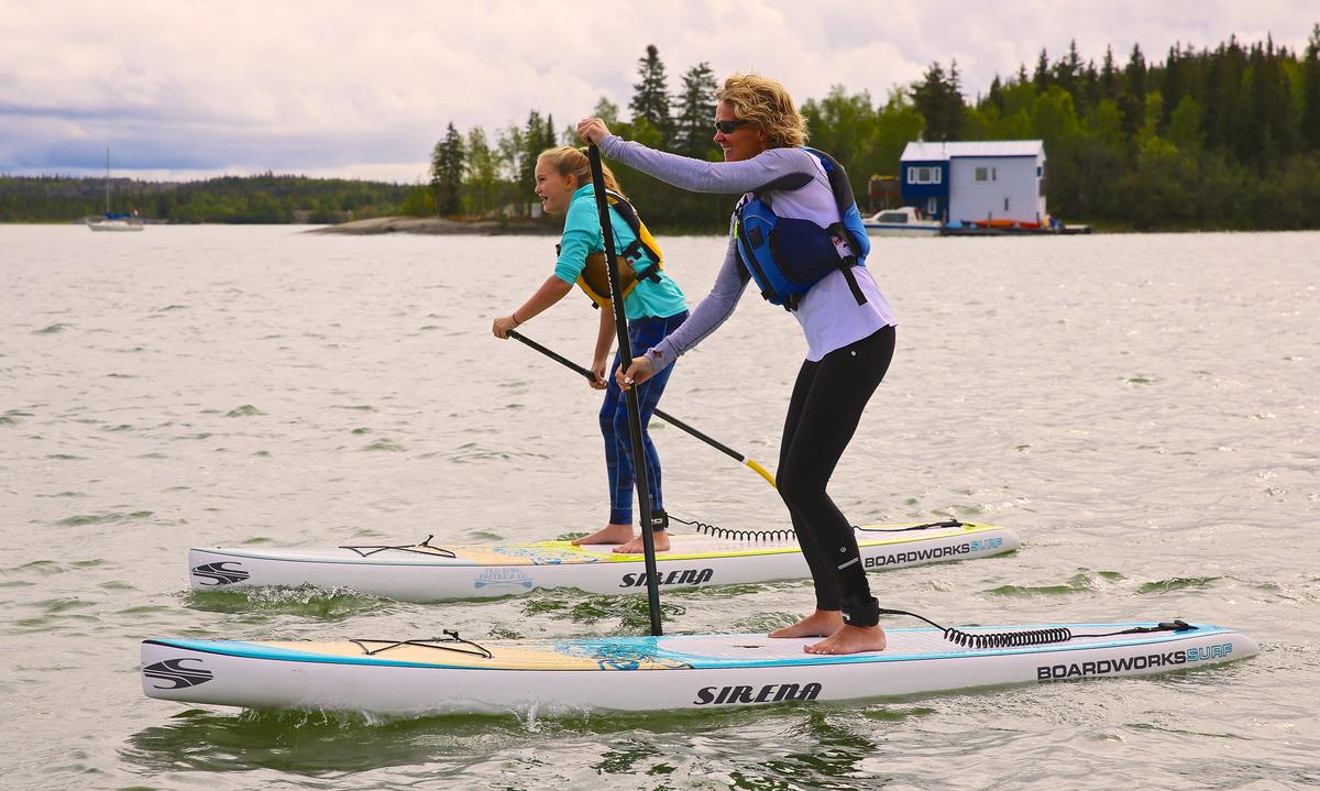 Two people paddle board on the lake